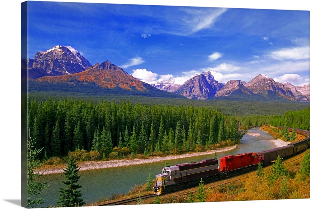 Big canvas photo art of a train running through the Canadian countryside with forests surrounding it and rugged mountains ...
