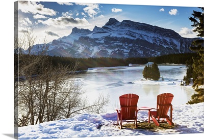 Two Red Chairs On Snow Covered Ridge Overlooking Frozen Lake, Banff, Alberta, Canada