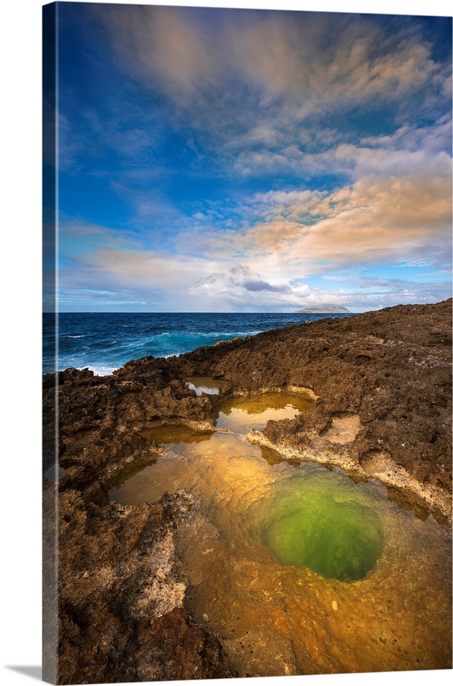 Volcanic rock formations and sunlight reflecting in the green tidal pool on the beach at Pointe des Chateaux, Grande-Terre...