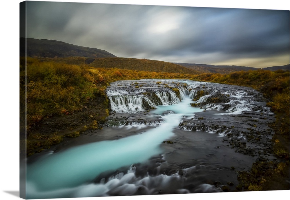 Long Exposure Of Water Flowing Over Rock In A Stream And Dark Clouds In The Sky, Bruarfoss, Iceland