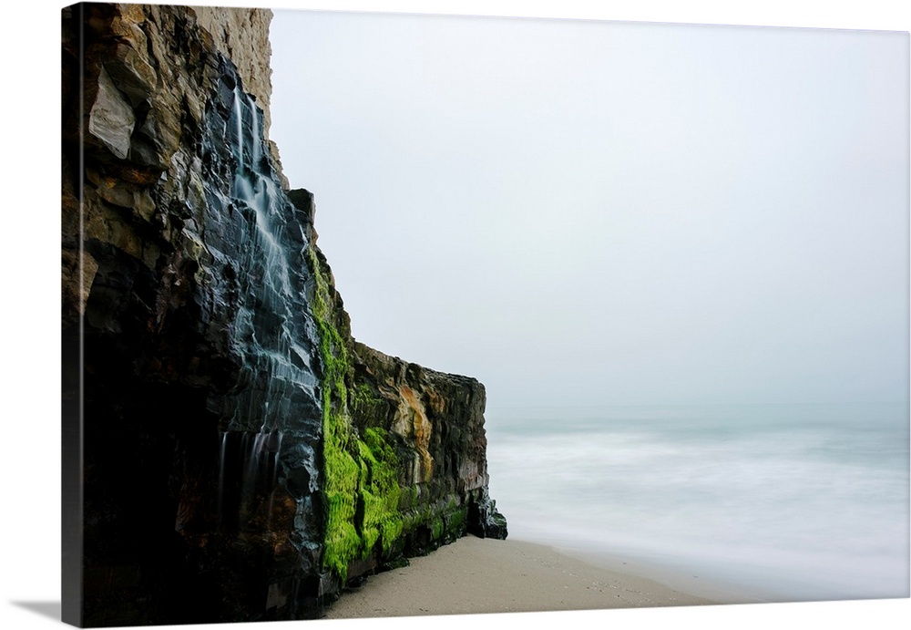 Waterfall over the rugged cliff along the beach and coast at Wilder Ranch State Park Santa Cruz, California, United States...