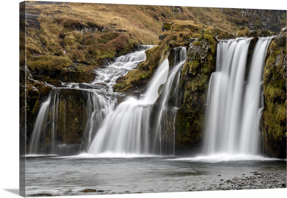 Waterfalls cascading over the cliffs in the rugged countryside Iceland