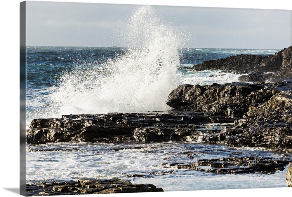 Wave crashing into rocky coast with cloudy sky, Kilkee, County Clare, Ireland