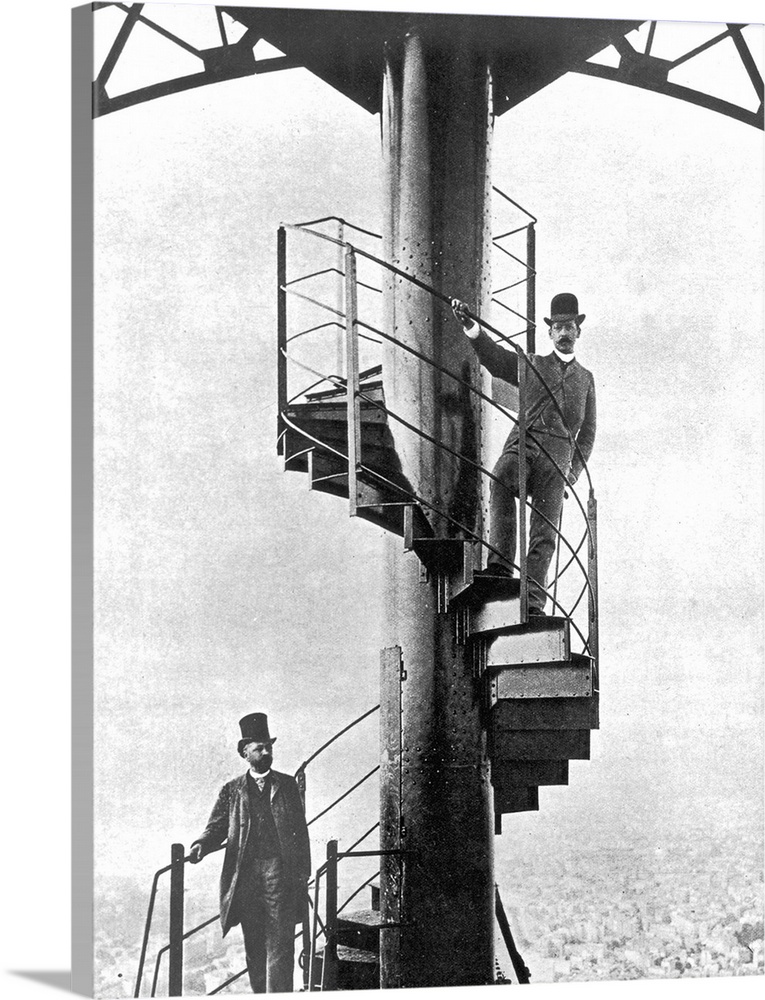 French engineer Alexandre Gustave Eiffel (1832 - 1923), left, poses high on the steps of the completed Eiffel Tower, which...