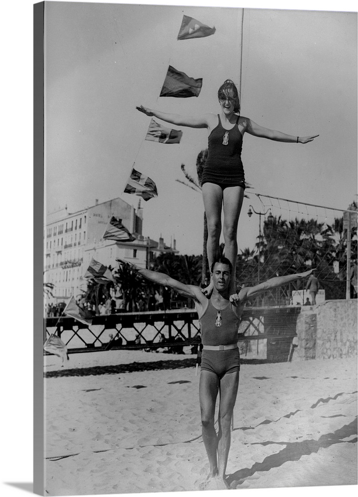 4th March 1931:  Jean Rouma and partner do a balancing act on the beach at Cannes