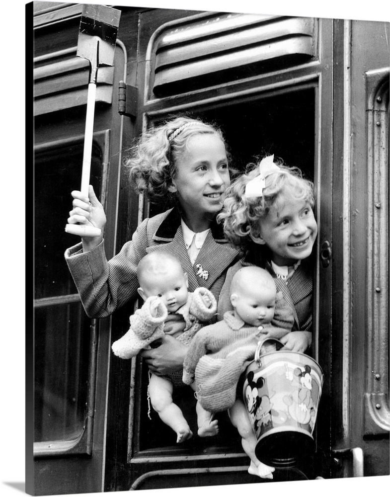 31st July 1937:  Two young girls peering out of a train window at Euston Station, London, before leaving for a bank holida...