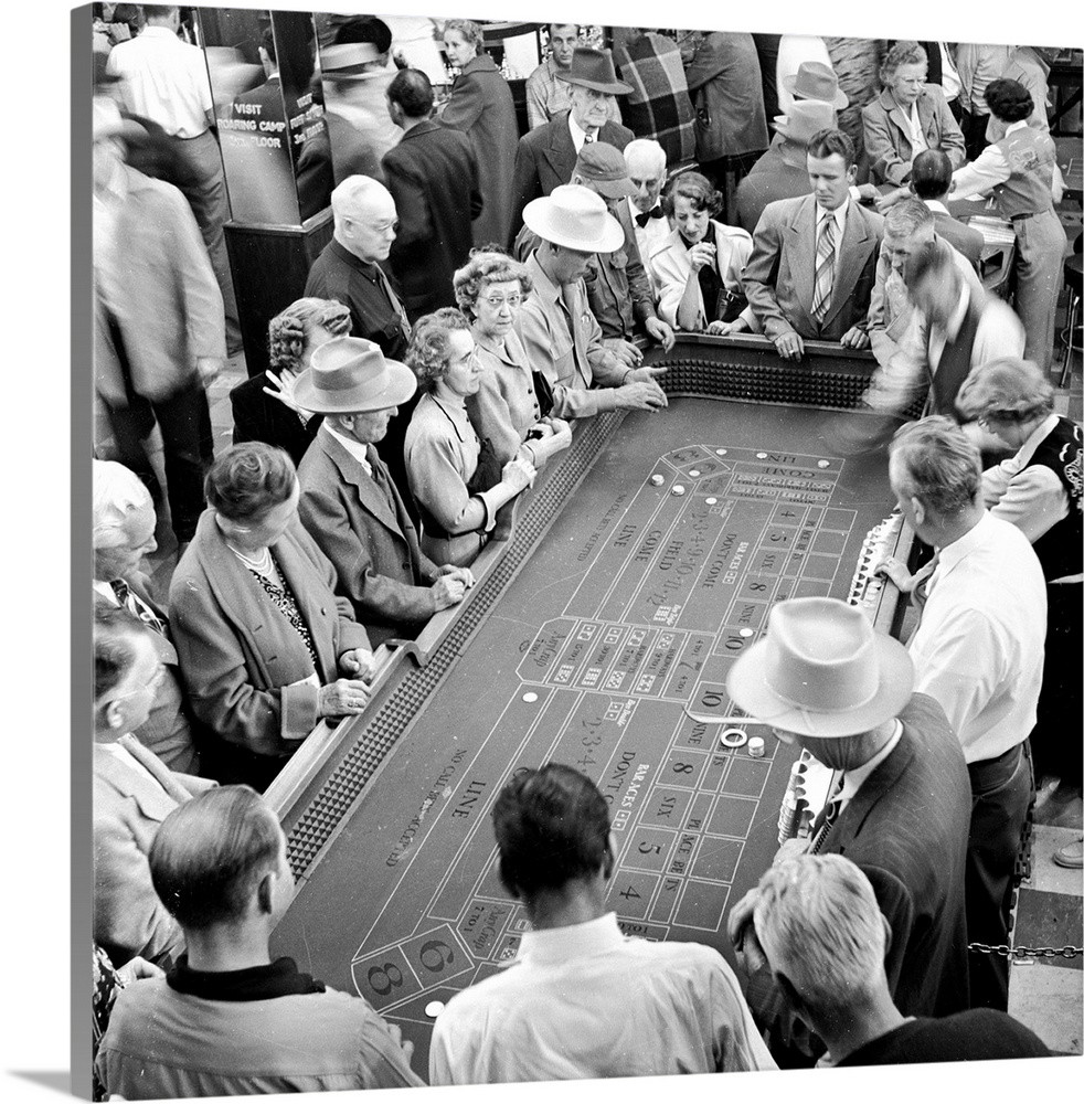 20th December 1950:  Gamblers gather round a table in Harold's Club, the largest gambling house in Reno, Nevada