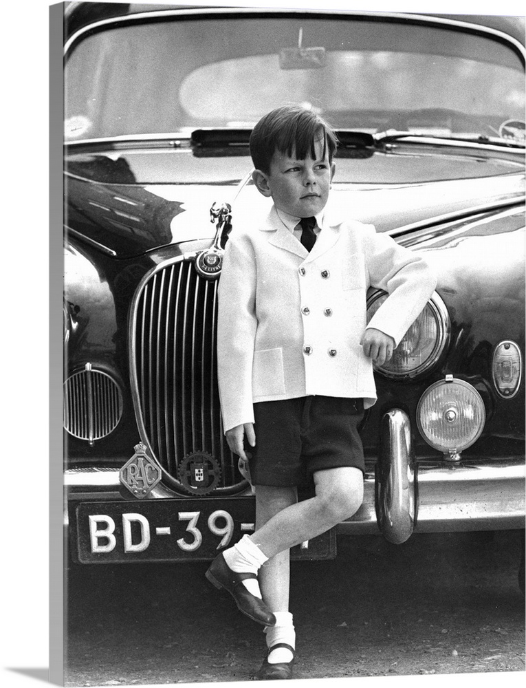 A little boy models a knitted Italian double breasted jacket with brass buttons and knitted Italian shorts from Jaeger's c...