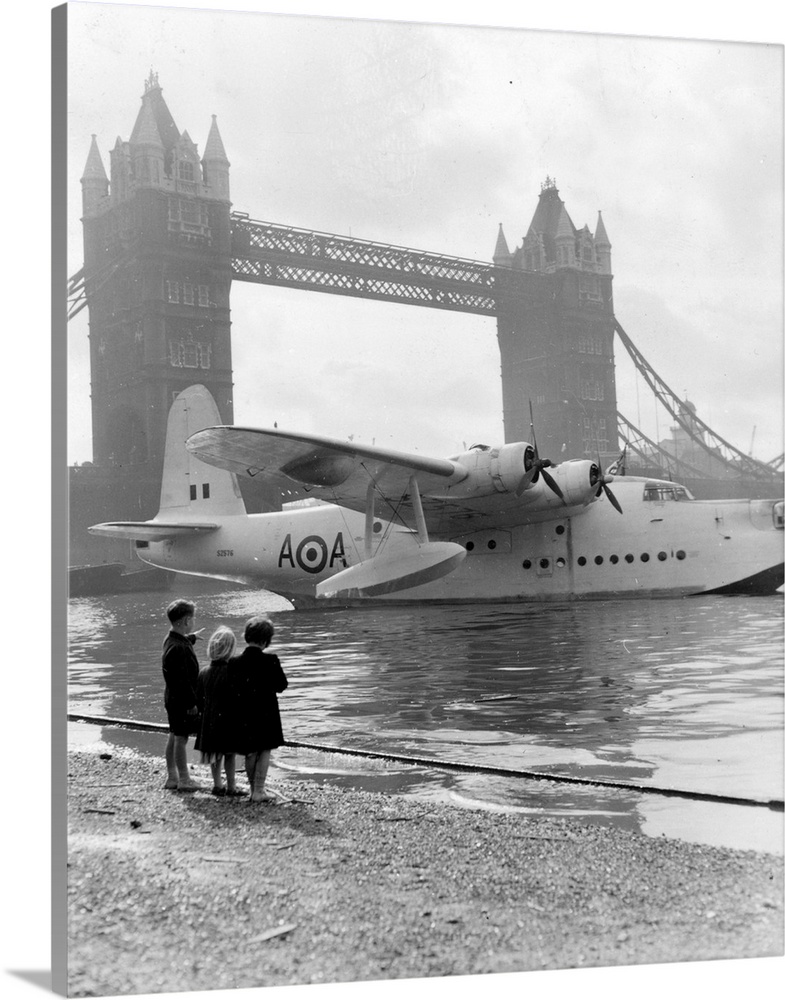 Three children looking at an RAF Short Sunderland Mark V flying boat moored beside the Tower of London during Battle of Br...