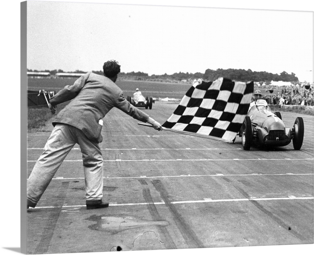 26th August 1950:  Giuseppe Farina (Nino Farina) receiving the chequered flag at an International Trophy Race at Silverstone