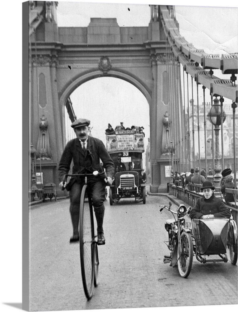 A cyclist riding a penny farthing over Hammersmith Bridge, London