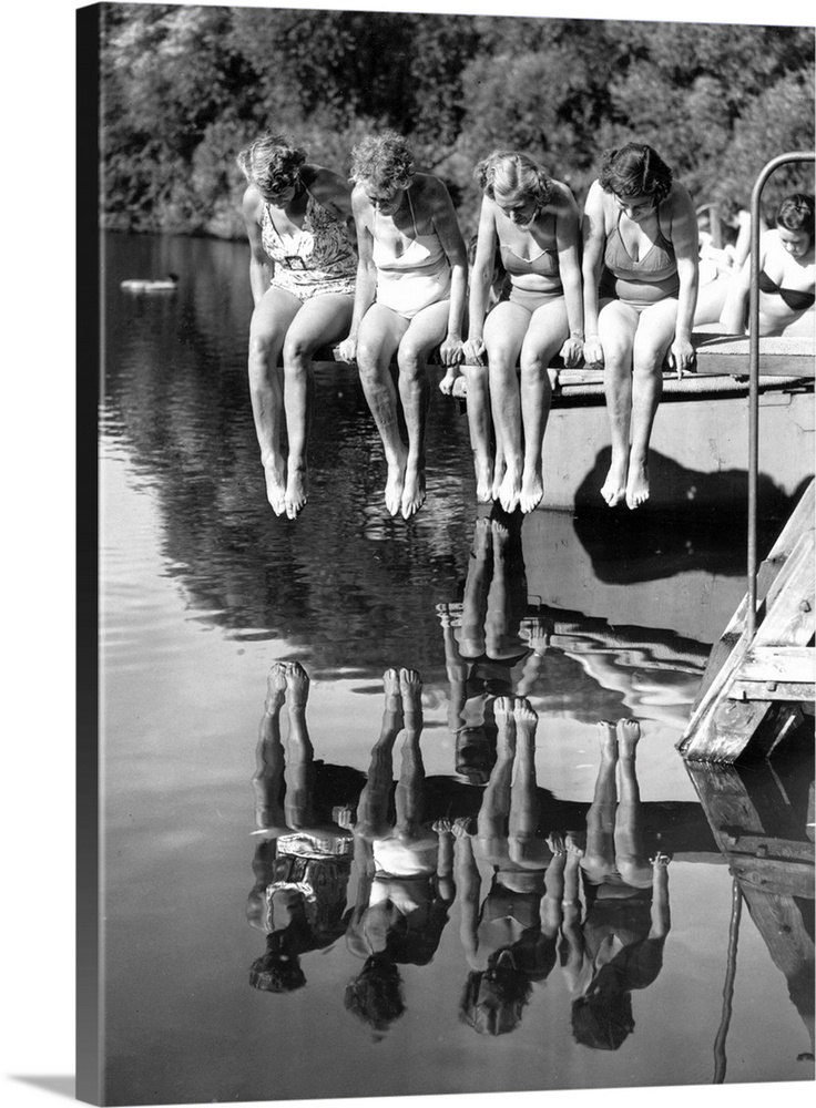Four swimmers sit on a diving board admiring their reflections in Kenwood open-air swimming pool