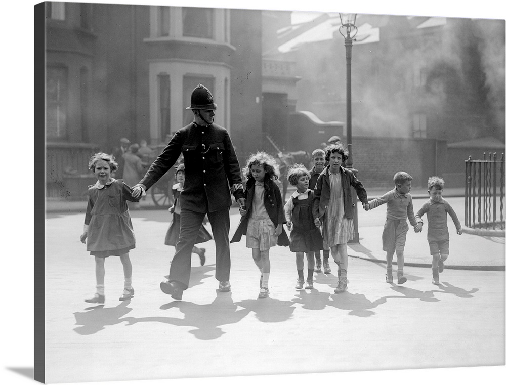 A London policeman escorts a group of children across a road at Chelsea