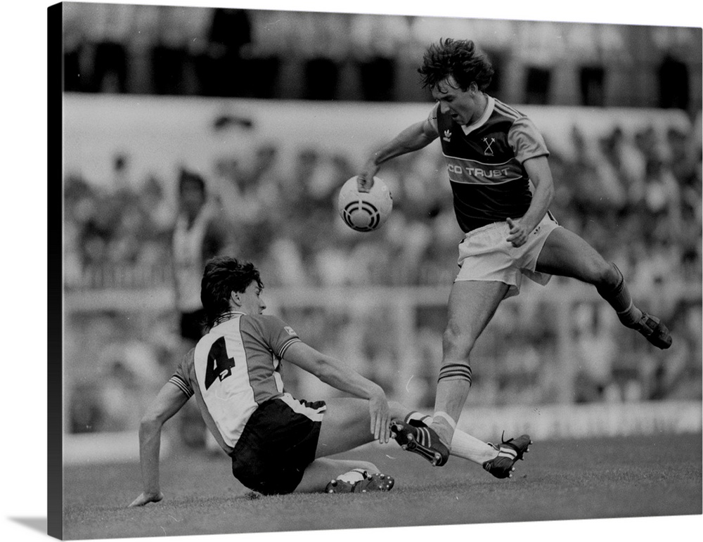 circa 1984:  Southampton footballer, Steve Williams, challenging Paul Allen of West Ham