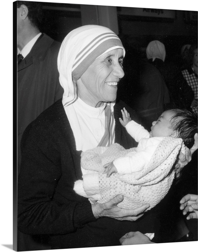Christian missionary Mother Teresa of Calcutta (1910 - 1997) holding a baby at Heathrow Airport, London