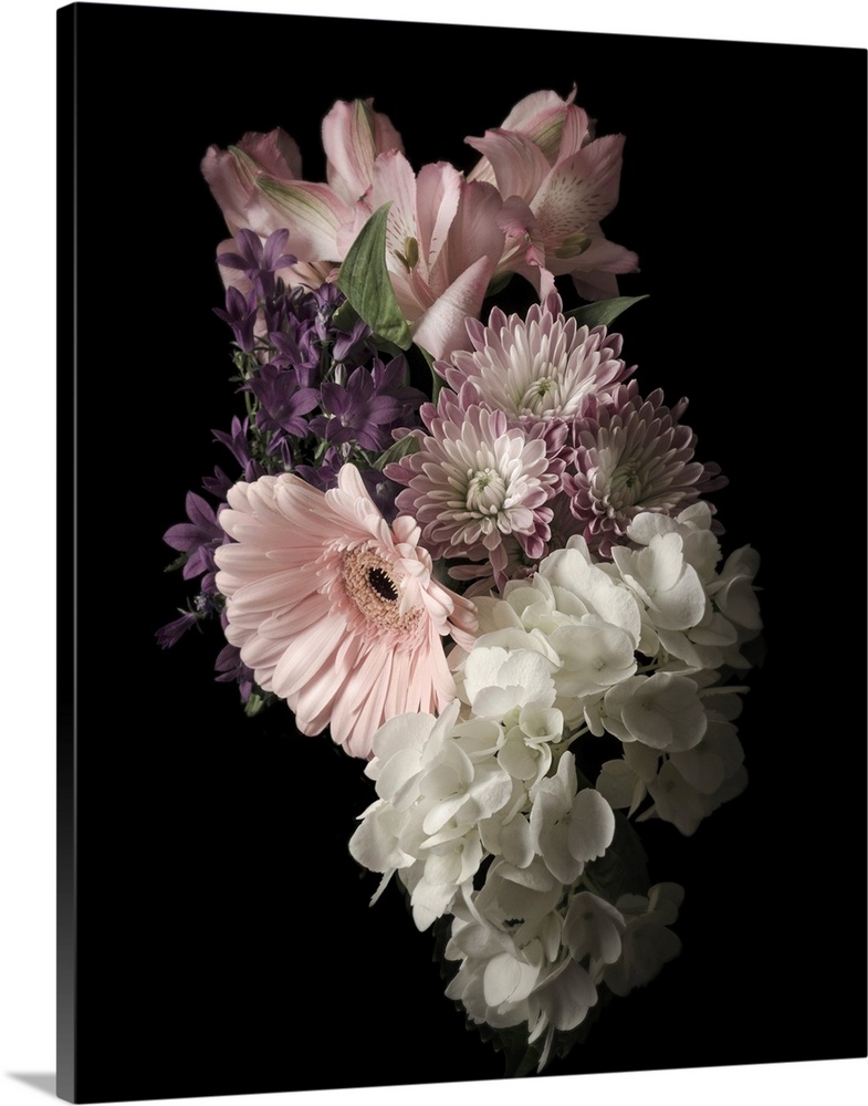 Moody photograph of a bouquet of pastel flowers on black in low light.