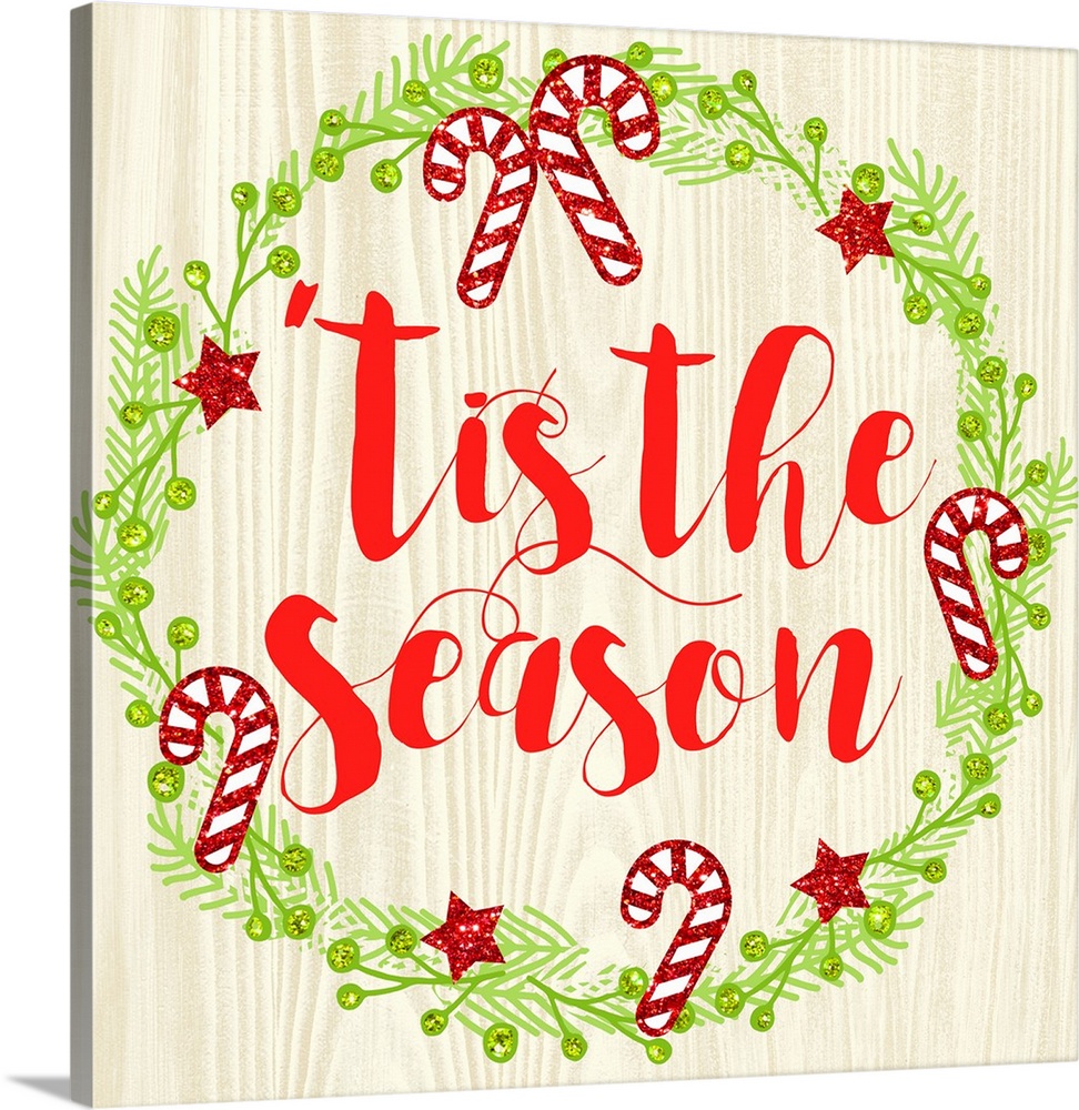 "Tis The Season" written in red inside of a Christmas wreath on a faux wood background.