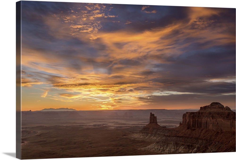 A photograph of desert landscape illuminated by a warm sunset.