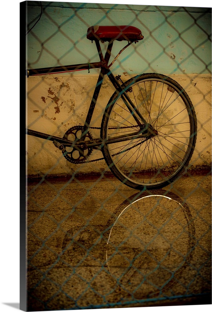 Photograph of the rear of a bicycle behind a chain link fence with a black vignette.