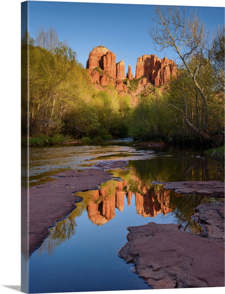 Landscape photograph of Cathedral Rock reflecting into a low, rocky river, Sedona AZ.