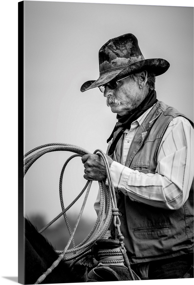 Black and white portrait of a cowboy  holding a lasso.