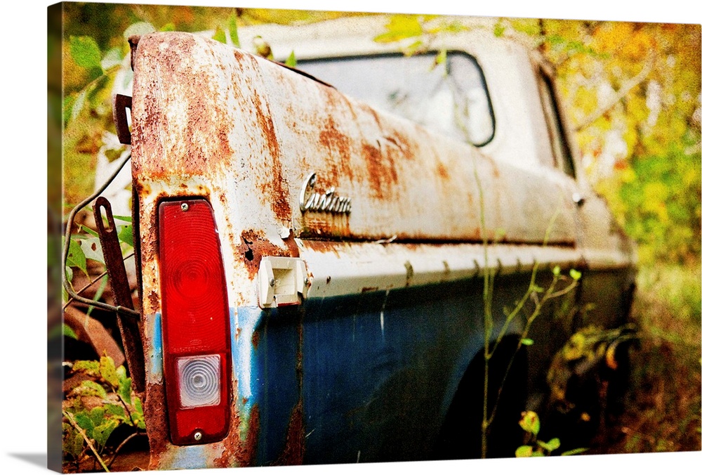 Photograph of a derelict truck in the woods.