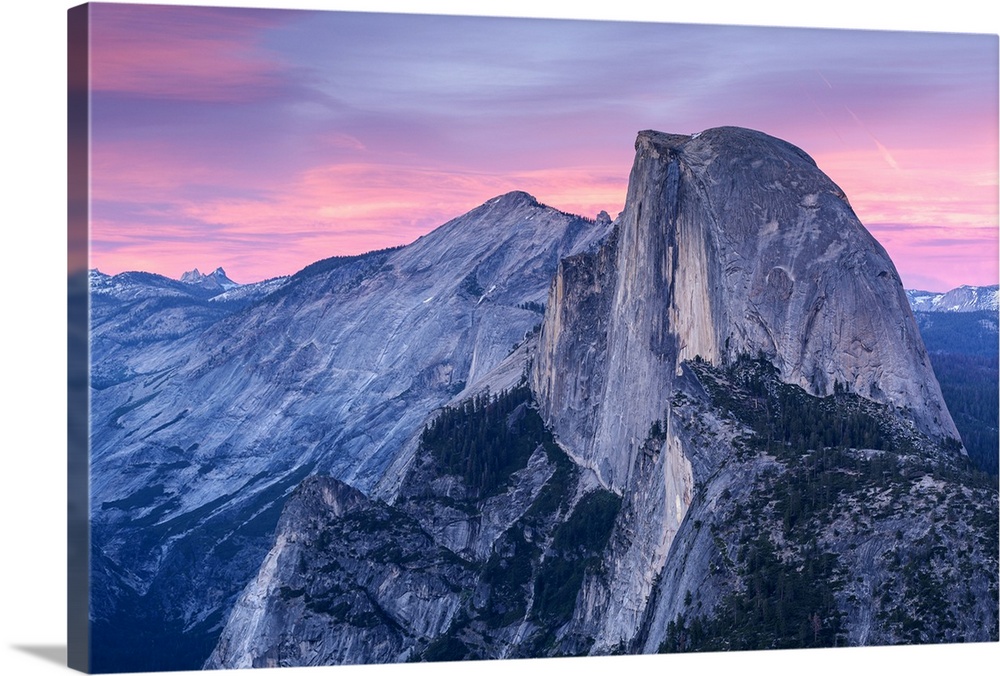 Half Dome in Yosemite with pink clouds in the sky.