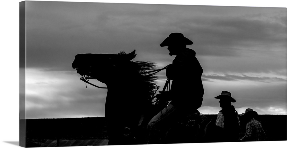 Black and white silhouette photograph of a cowboy on horseback.