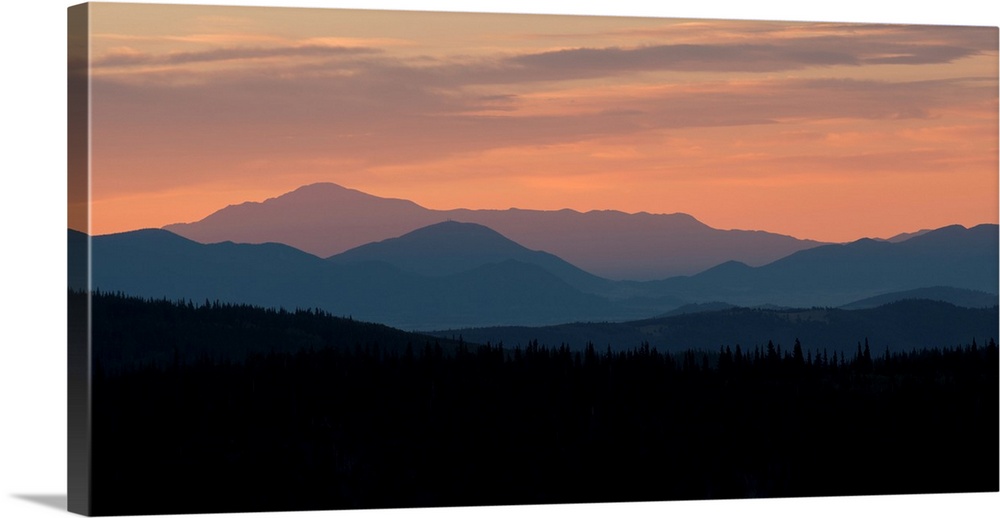 Landscape photograph of a silhouetted mountain range at sunset.
