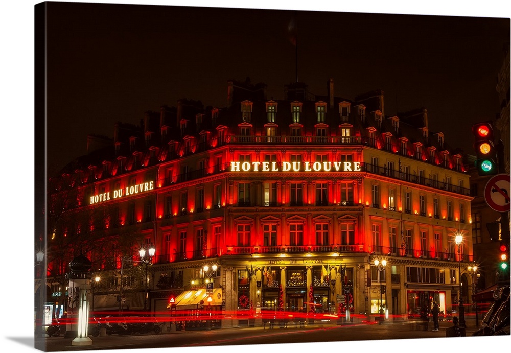 A photograph of the Hotel du Louvre at night.