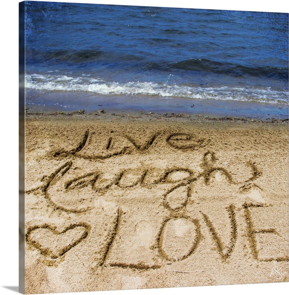Photograph of a motivational sentiment written in the sand on a beach.