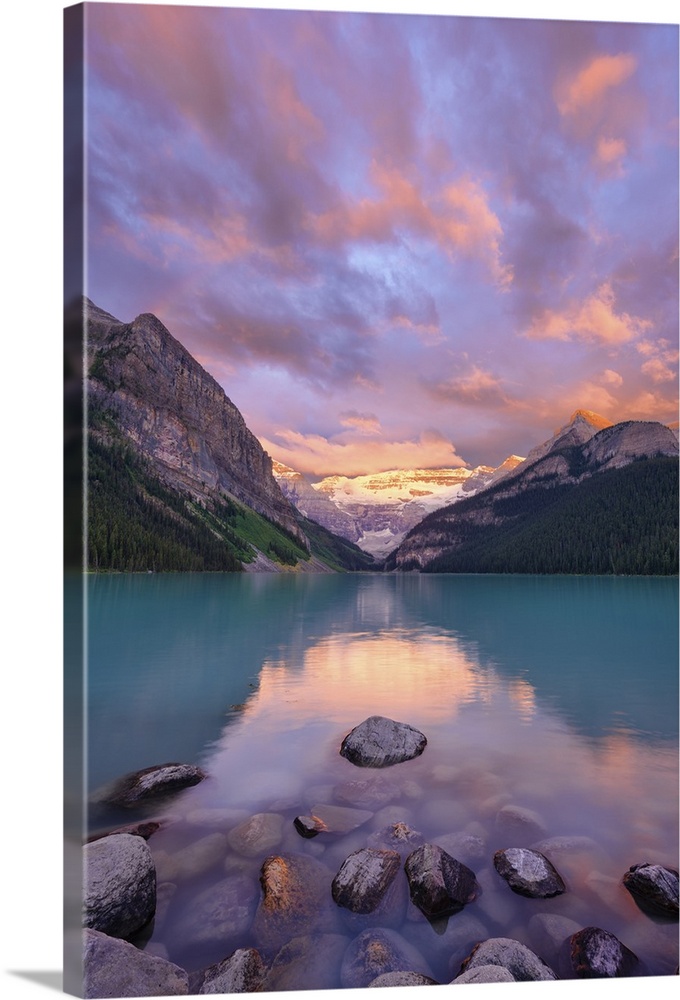 An artistic photograph of a wilderness lake reflecting the mountains and forest surrounding it.