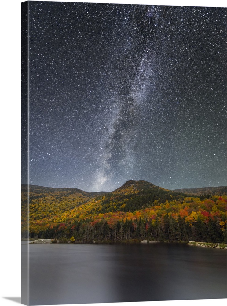 Nighttime landscape photograph of Beaver Pond with Autumn trees and a starry sky highlighting the Milky Way.