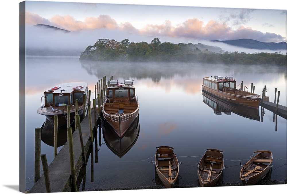 Small boats docked at wooden piers on a lake in Cumbria.