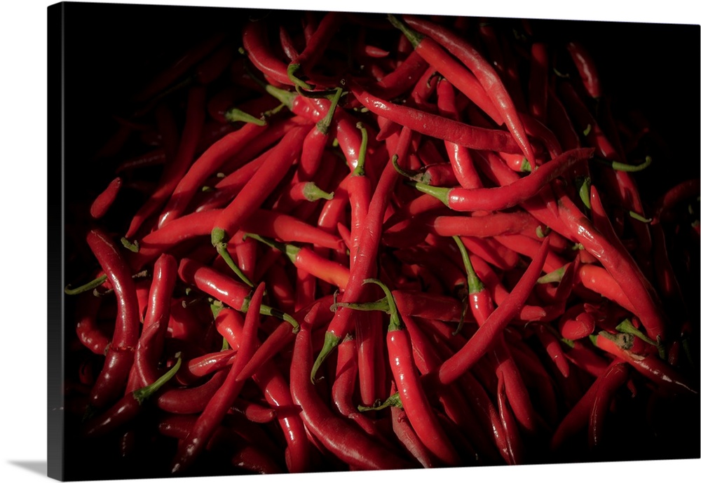 Photograph of red cayenne peppers with a black vignette.