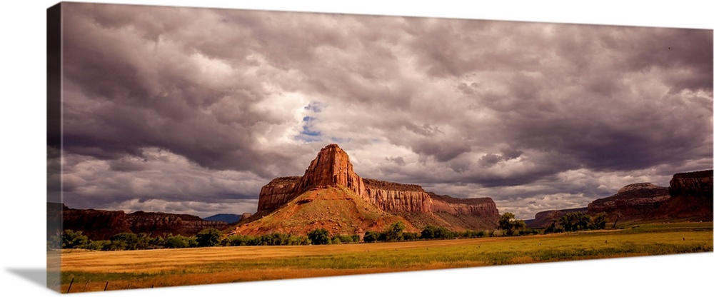 Landscape photograph of large rock formations under a cloudy sky.