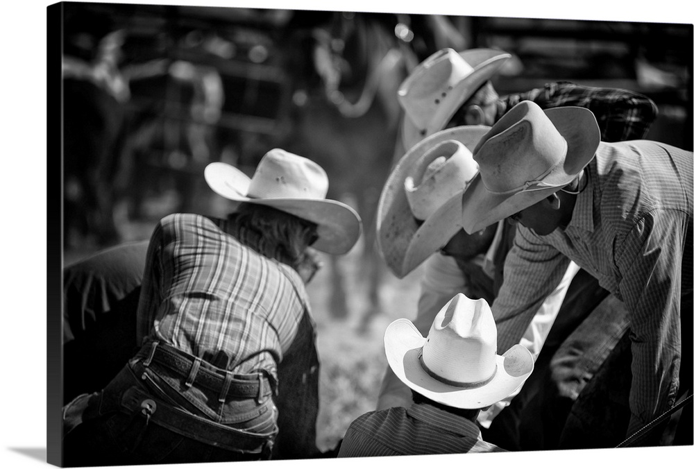 Black and white photograph of a group of people wearing cowboy hats at a rodeo.
