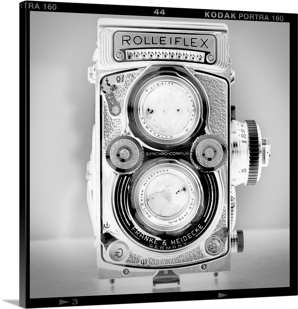 A black and white fine art photograph of an antique rolliflex camera within a film cell border