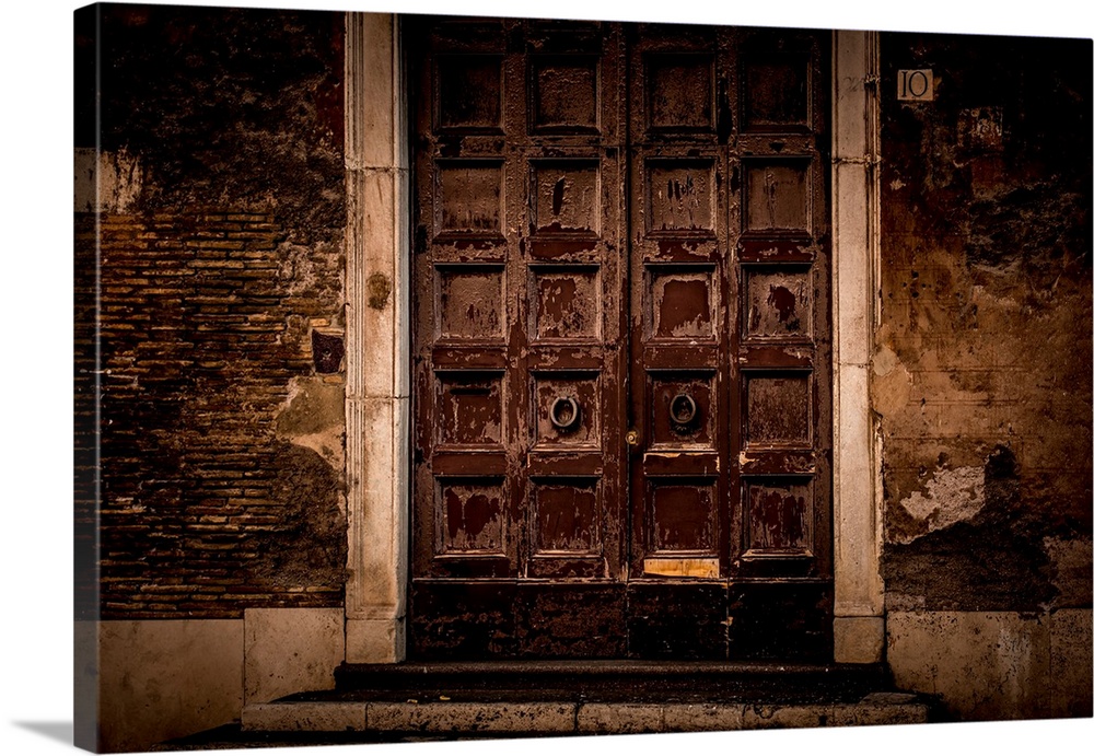 Photograph of large, old, wooden front doors on a run down facade.