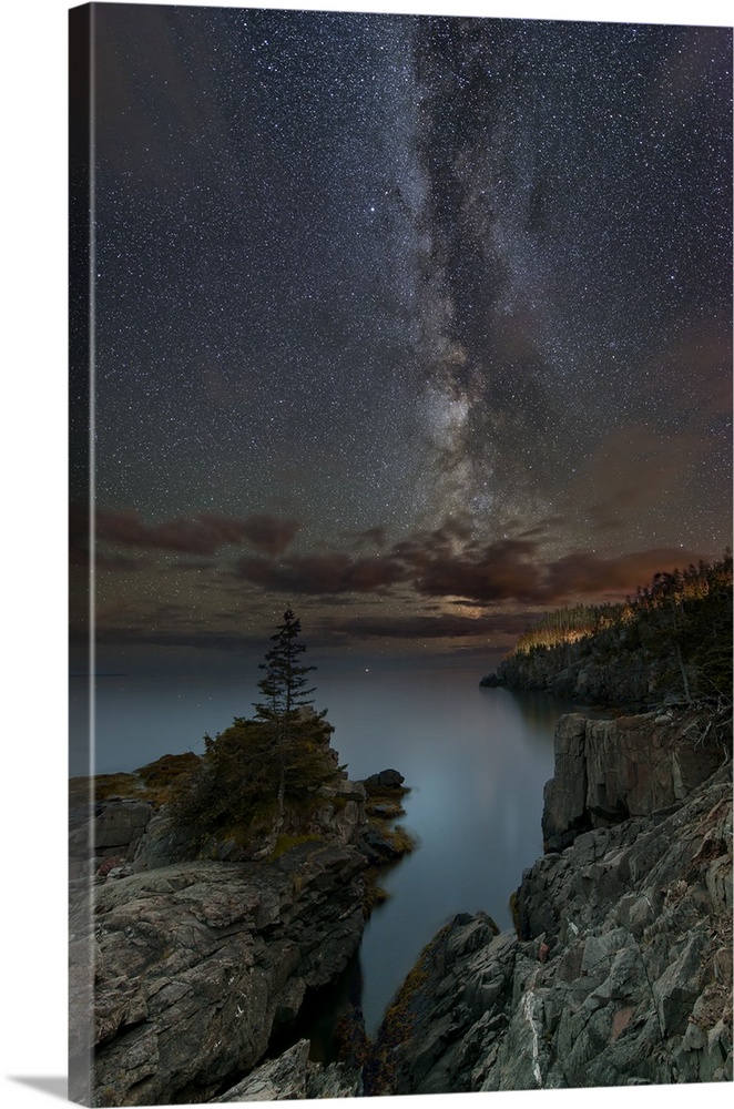 Long exposure photograph of the starry night sky over the Quoddy Channel at Quoddy Head State Park, Maine.