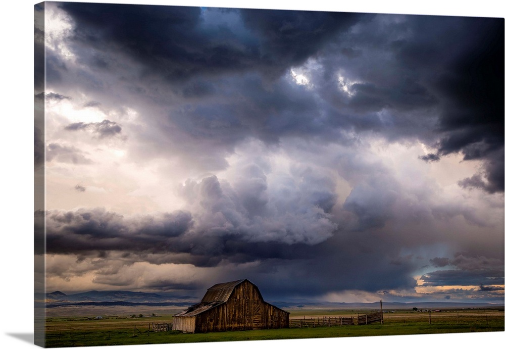 A photograph of a farm landscape under the dark clouds of an incoming storm.