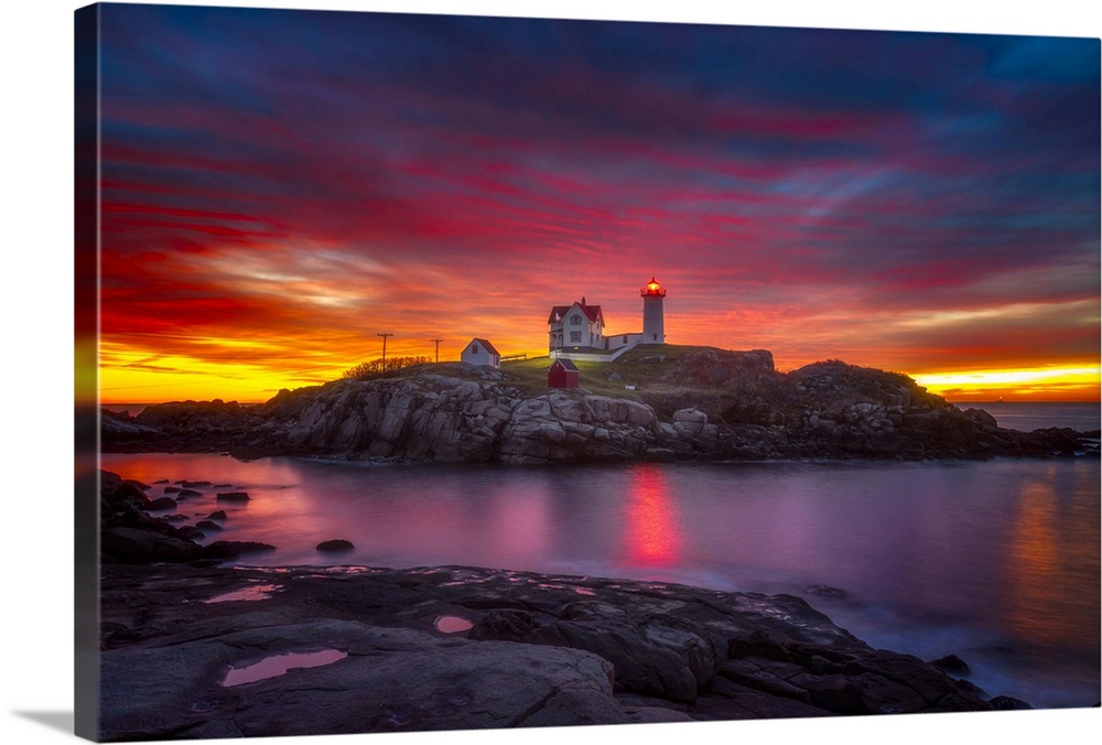 A vibrant sunset over Cape Neddick Lighthouse in York, Maine.