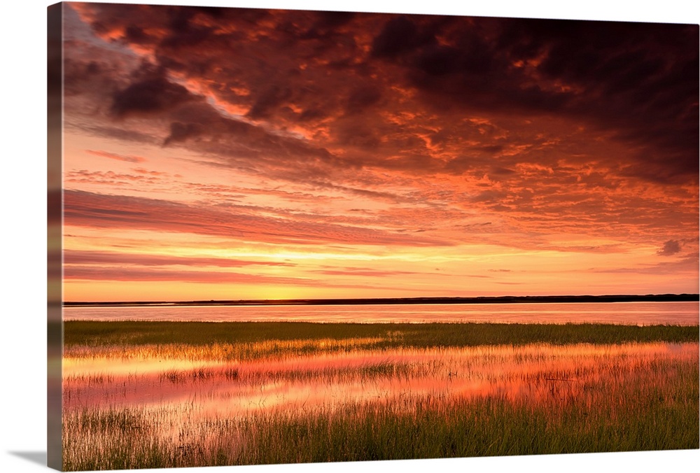 Vibrant sunrise reflecting off of marsh waters.