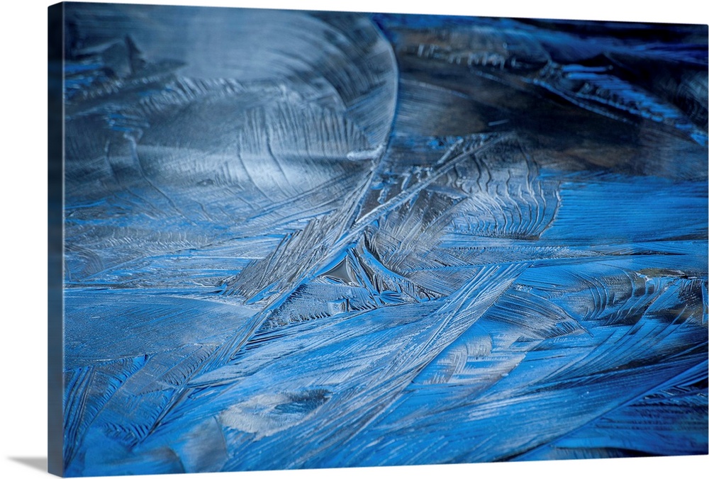 Close-up abstract photograph of the texture from frozen water in shades of blue.