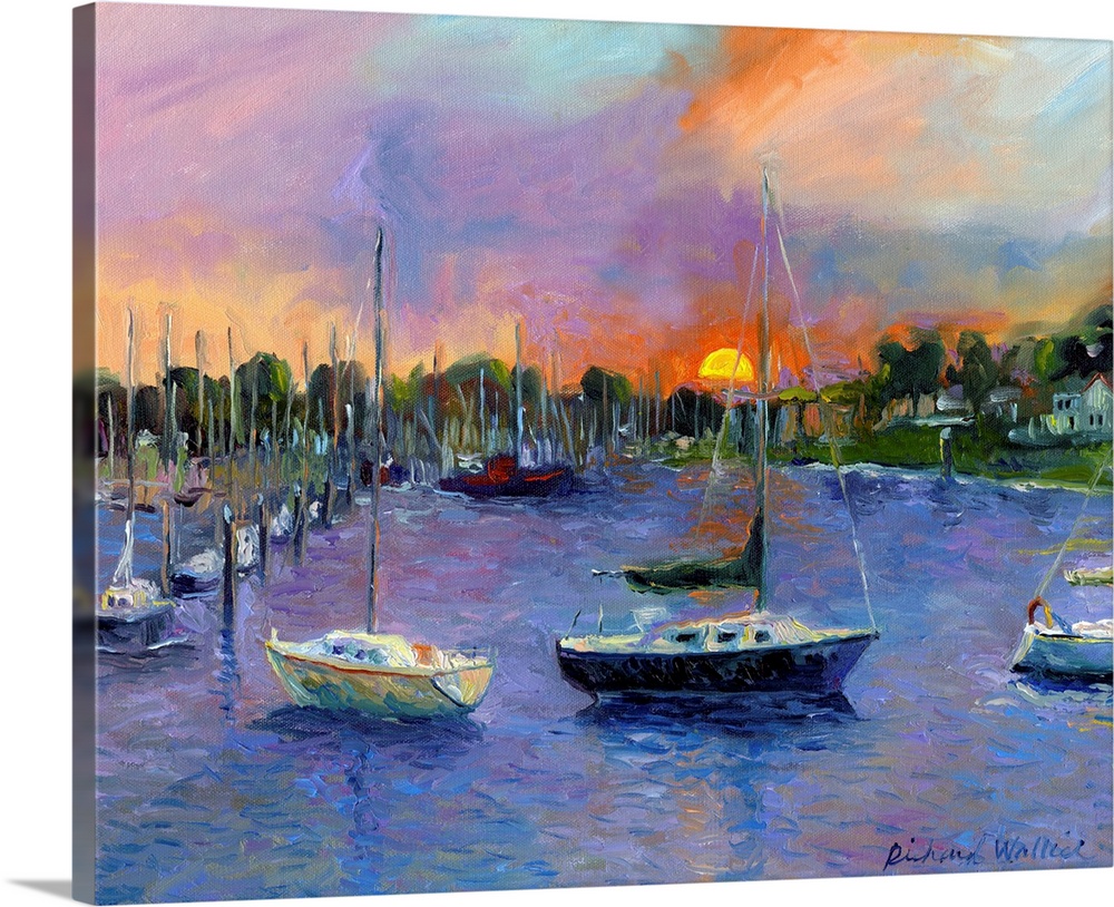 Sail boats in bay with sun setting in background.