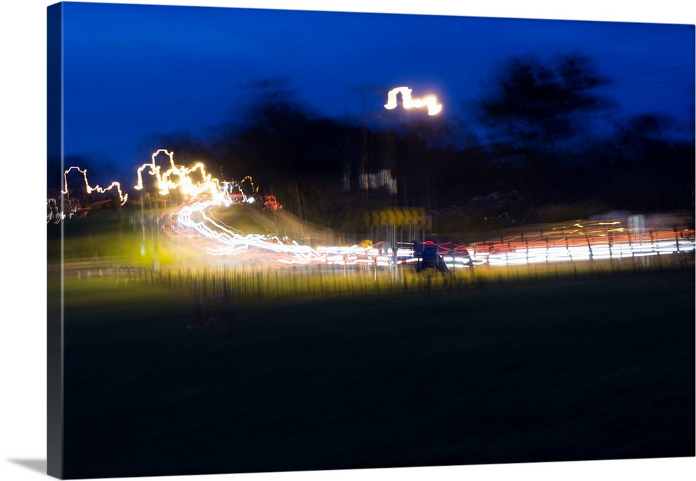 Impressionist photograph of a busy country road at night with cars light painting the road.