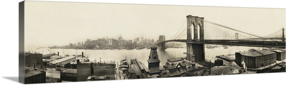 A vintage photograph of a the Brooklyn bridge spanning the East River toward Manhattan.