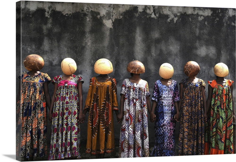 A high-impact fine art photograph of a group of women wearing stitched calabash gourds on their heads. These gourds are ne...