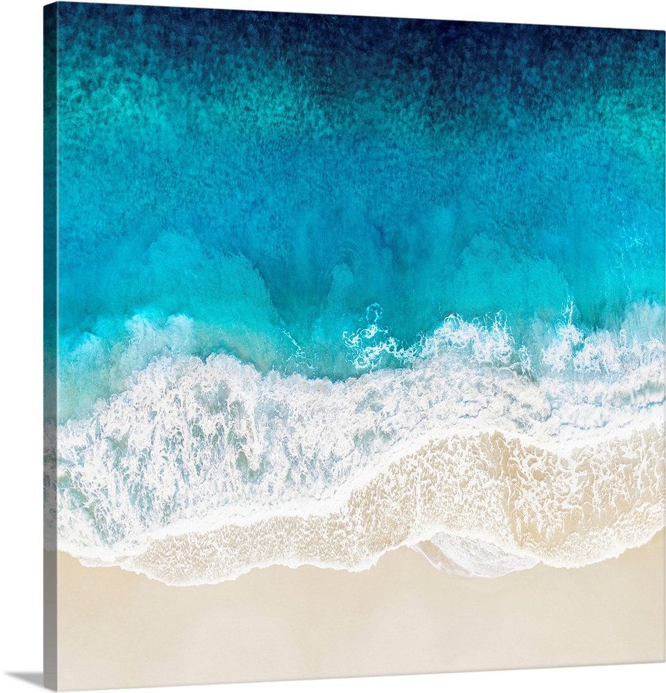 One artwork in a series of aerial shots of a beach as vibrant blue waves break upon the shore.