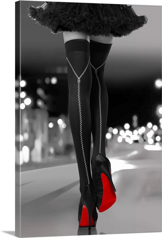 Black and white photograph of a woman's long legs with black high heels and bright red soles walking downtown.